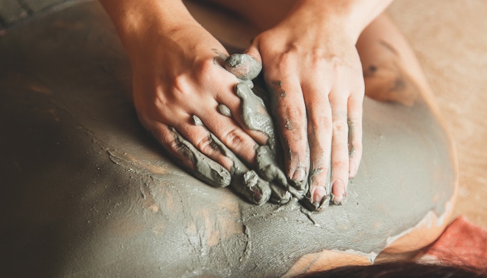 Visitors enjoying mud treatments at a spa in a serene outdoor setting.