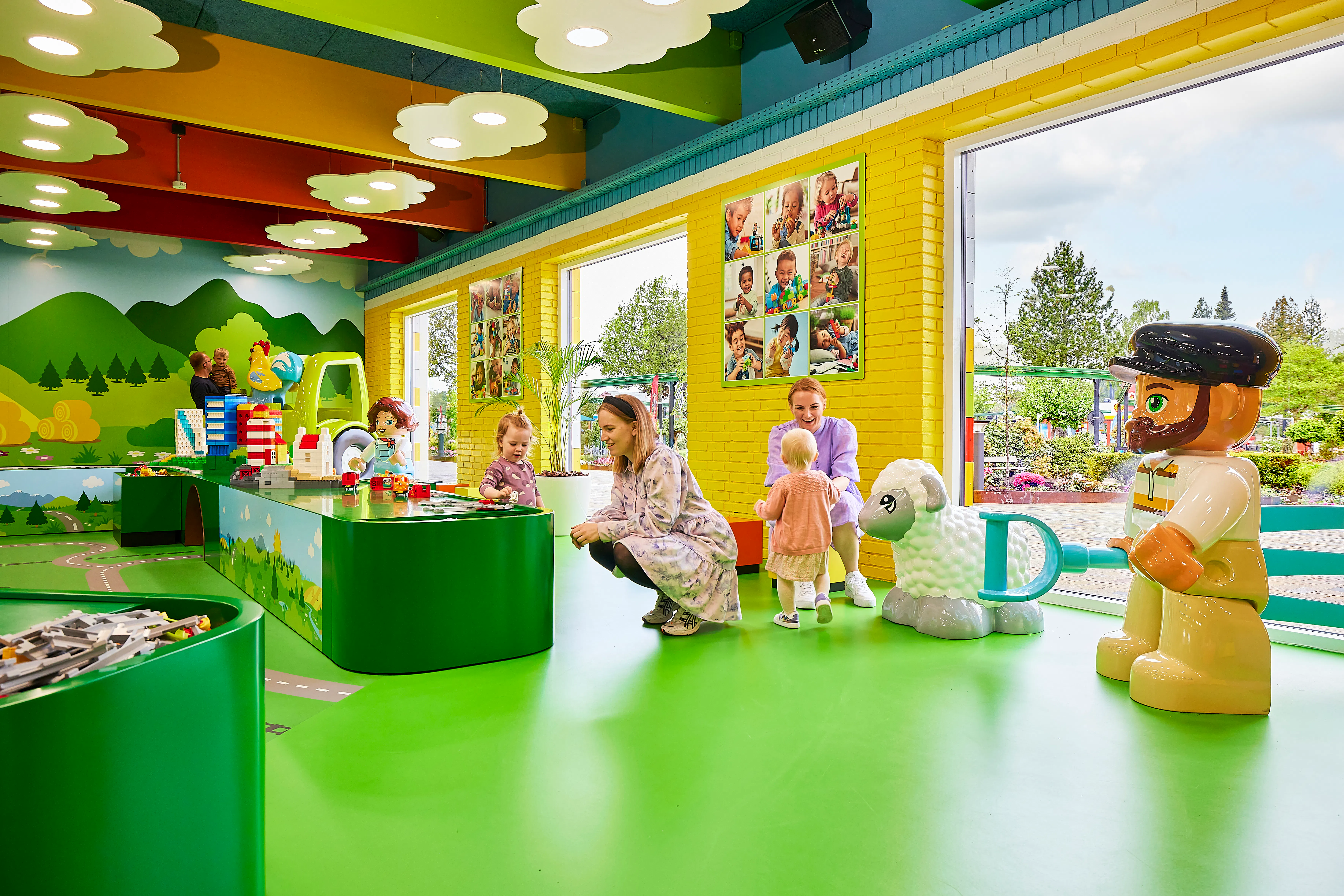 Children playing with LEGO bricks inside LEGOLAND Billund's colorful play area.