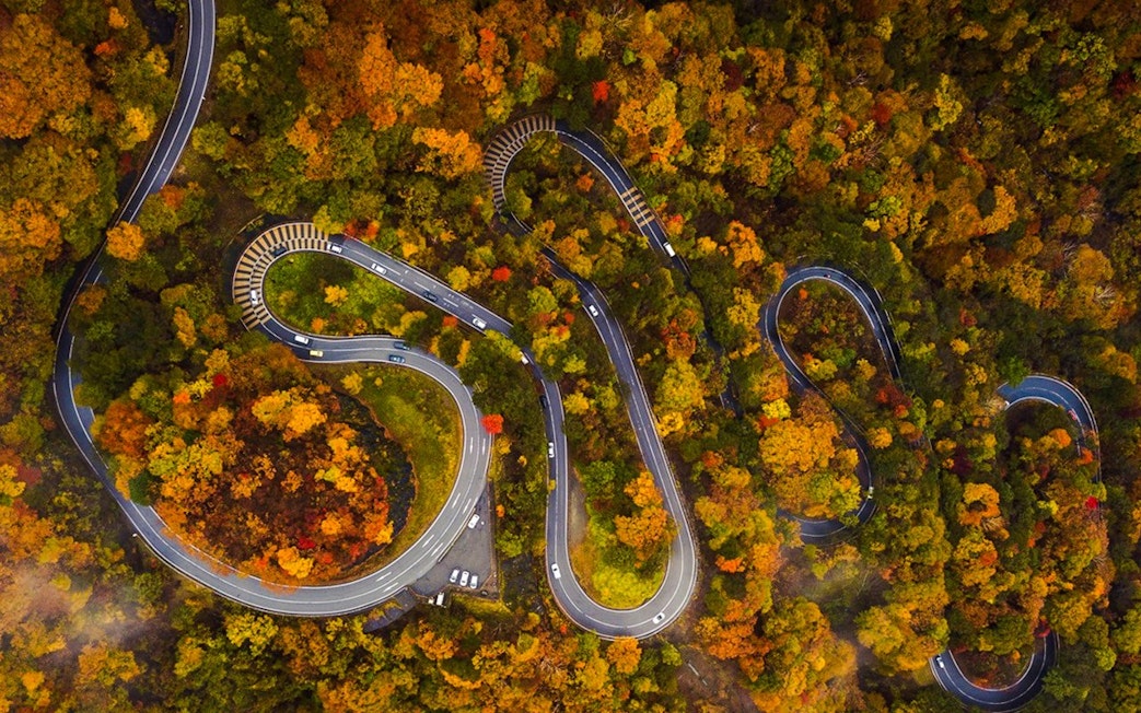 Irohazaka Winding Road in autumn, Japan, surrounded by colorful foliage.