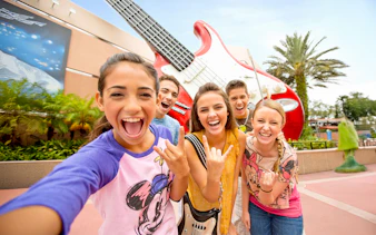 Guests smiling in front of a giant guitar statue at Walt Disney World Resort, Orlando.