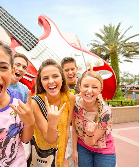 Guests smiling in front of a giant guitar statue at Walt Disney World Resort, Orlando.