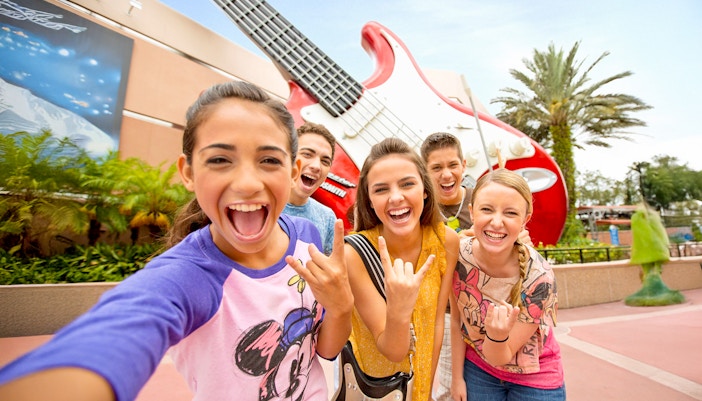 Guests smiling in front of a giant guitar statue at Walt Disney World Resort, Orlando.