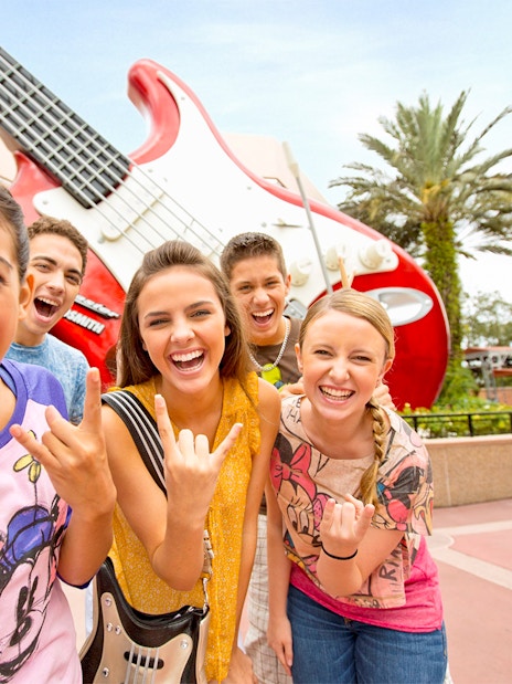 Guests smiling in front of a giant guitar statue at Walt Disney World Resort, Orlando.