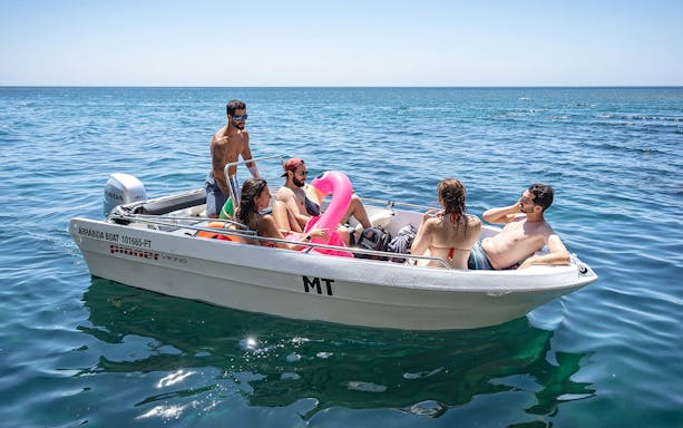 Private boat tour group enjoying Arrábida Natural Park waters.