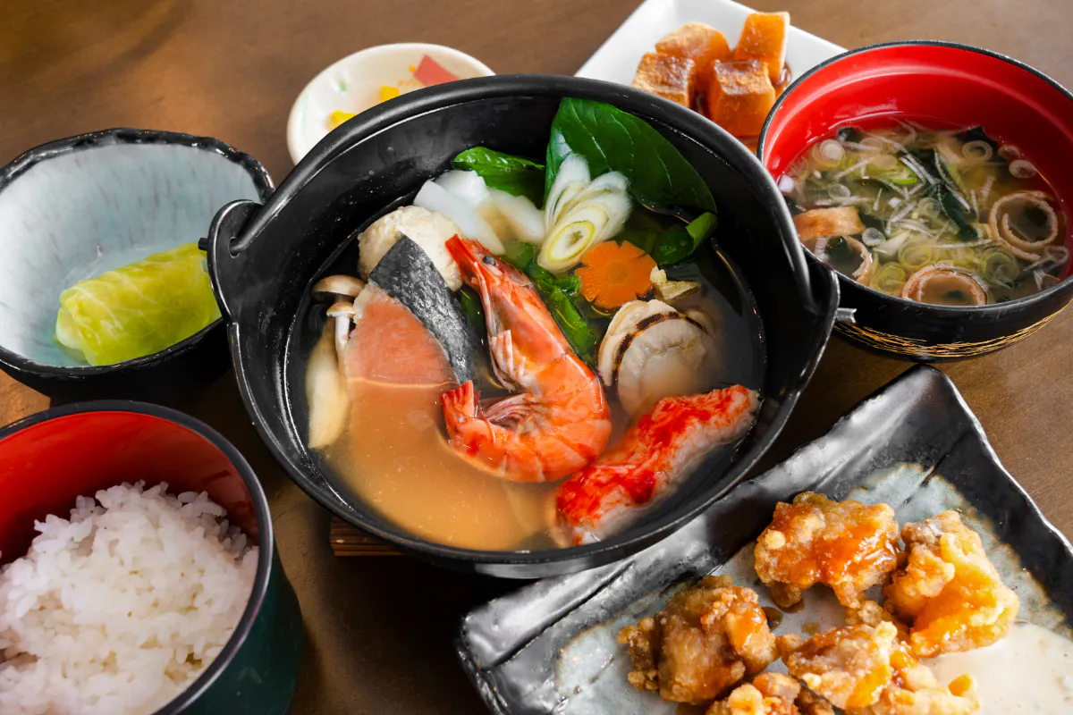 Traditional Japanese seafood hot pot with rice and side dishes, Sapporo to Bibai Snow Land tour, Hokkaido.