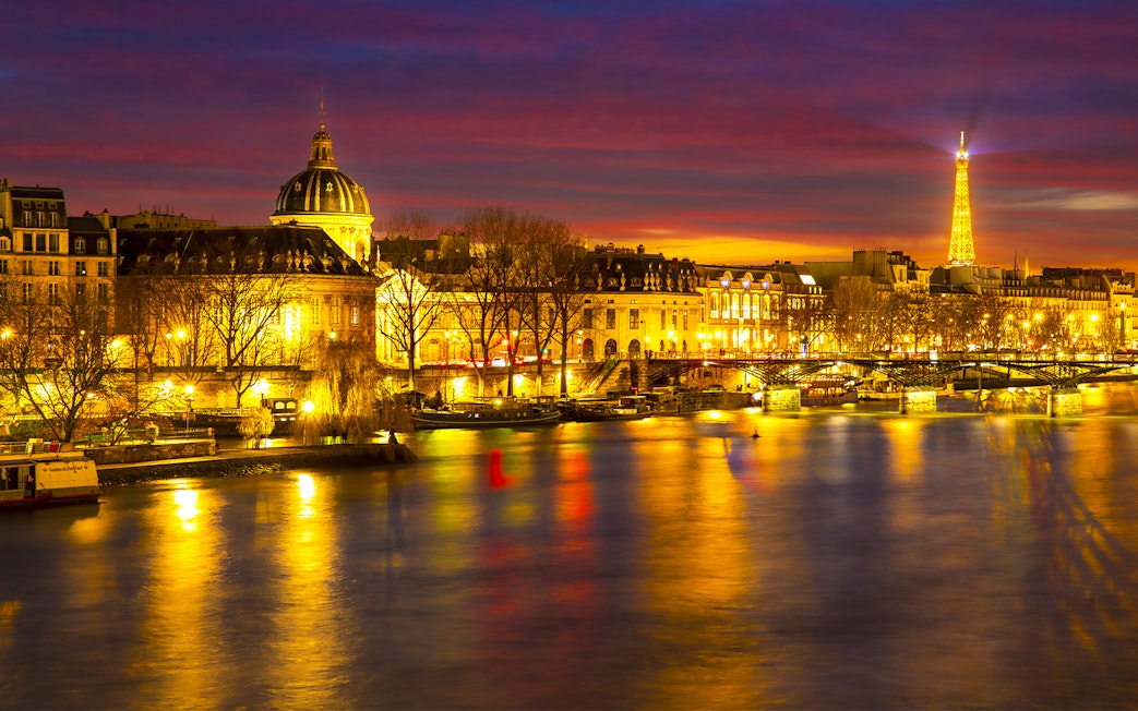 Paris night view with Eiffel Tower and Seine River, part of Tootbus Discovery Tour.