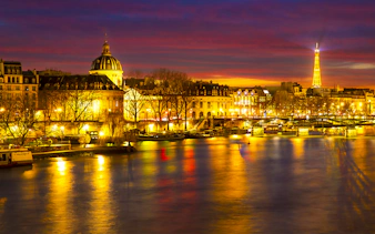 Paris night view with Eiffel Tower and Seine River, part of Tootbus Discovery Tour.