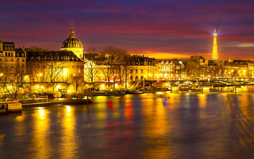 Paris night view with Eiffel Tower and Seine River, part of Tootbus Discovery Tour.