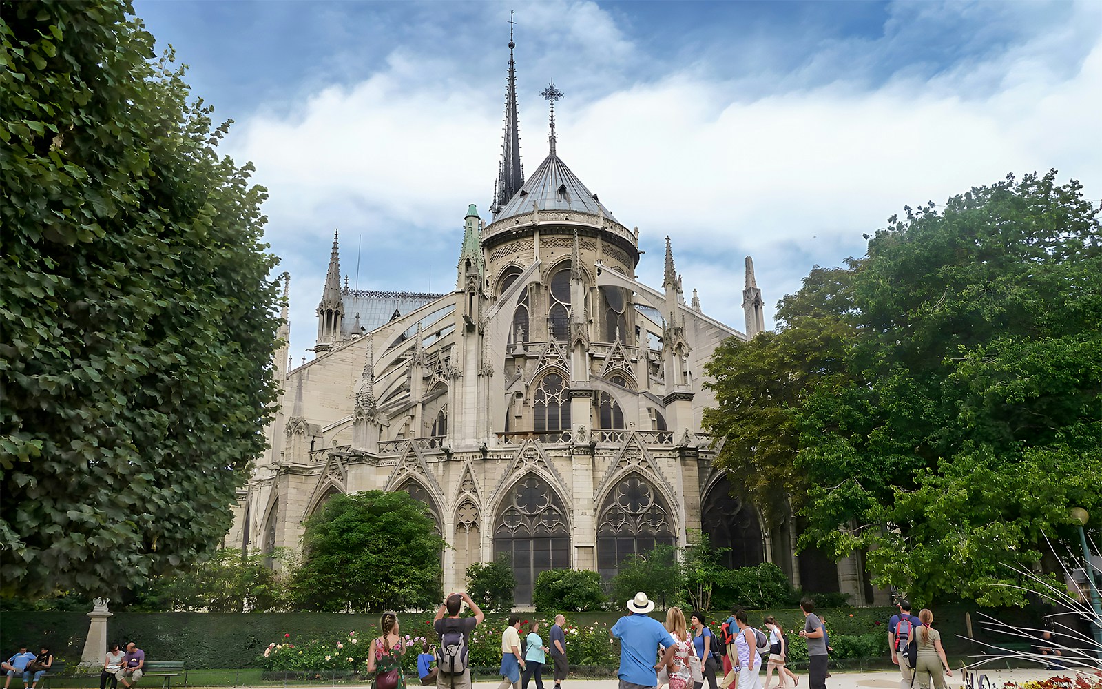 Notre Dame Cathedral facade with tourists on a walking tour in Paris.