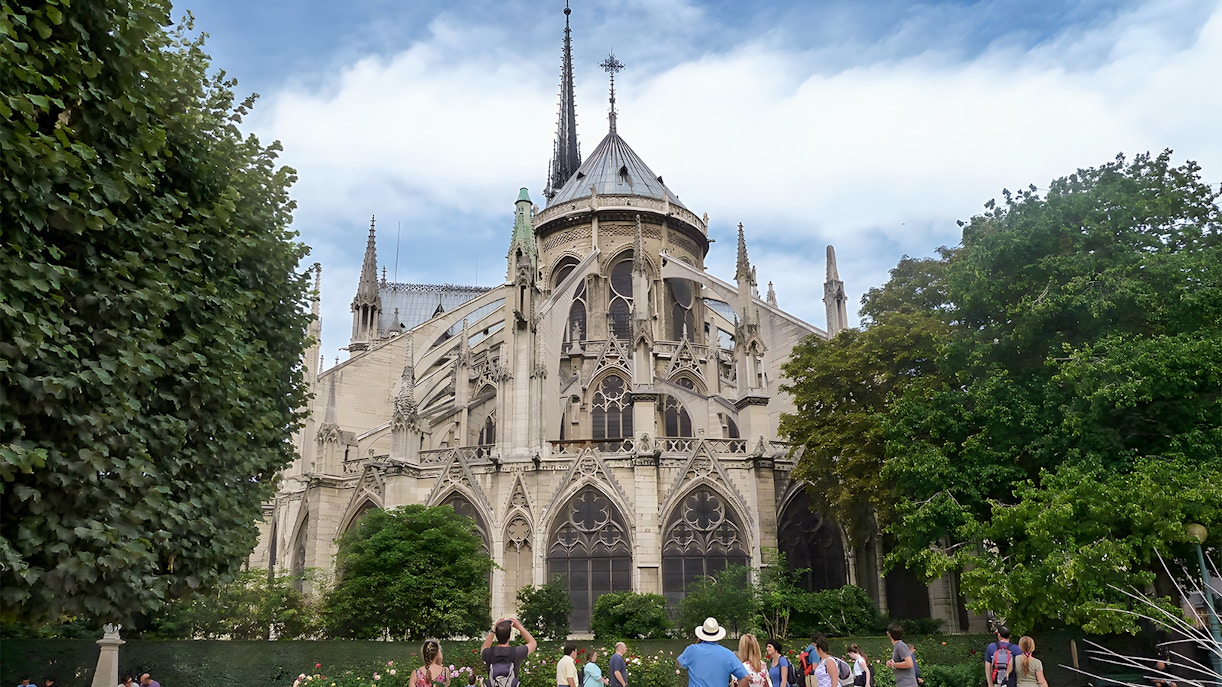 Notre Dame Cathedral facade with tourists on a walking tour in Paris.