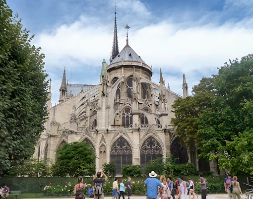Notre Dame Cathedral facade with tourists on a walking tour in Paris.
