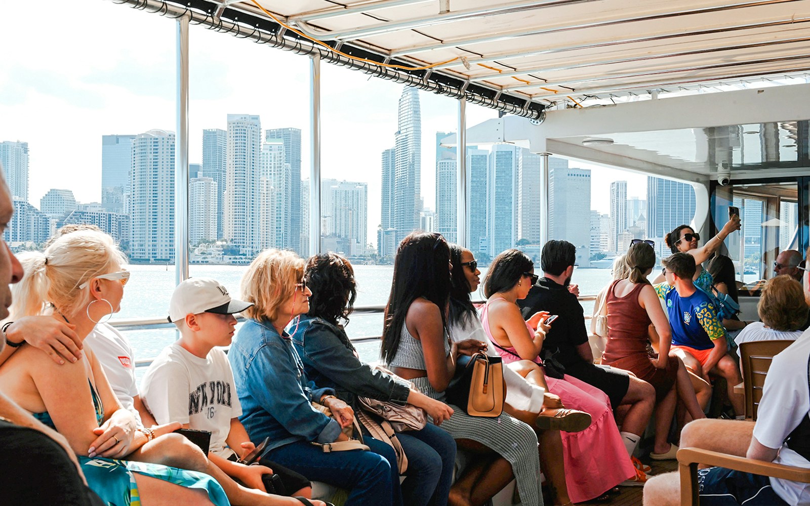 Guests enjoying a scenic cruise with Miami skyline in the background.