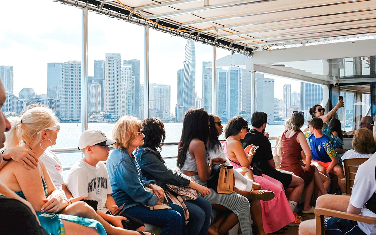 Guests enjoying a scenic cruise with Miami skyline in the background.