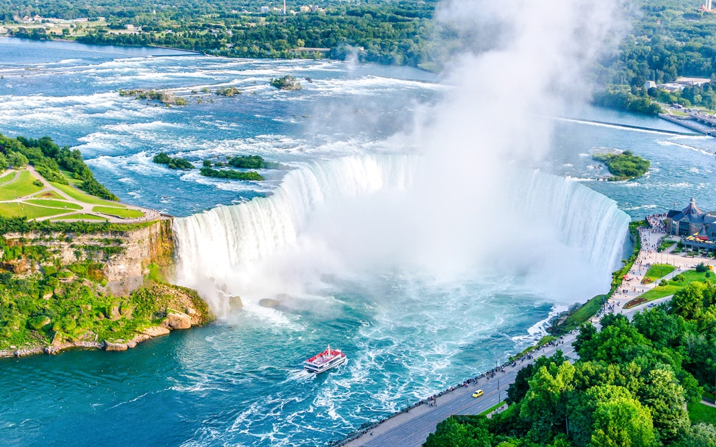 Aerial view of Niagara Falls with Horseshoe Falls and tour boat below.