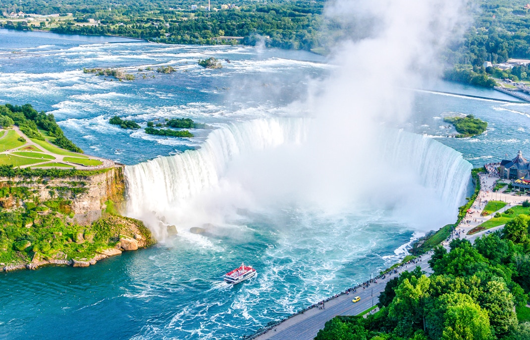 Aerial view of Niagara Falls with Horseshoe Falls and tour boat below.