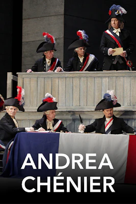 Men in historical costumes at a tribunal scene from Andrea Chénier opera.