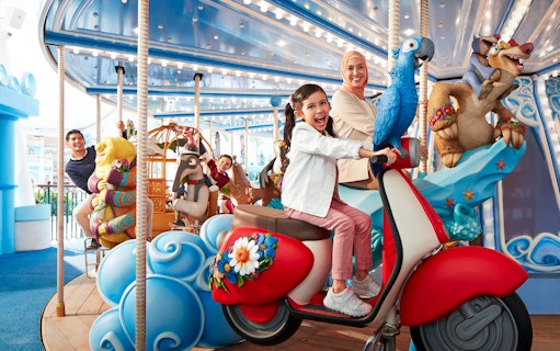 Visitors enjoying a colorful carousel ride at Genting SkyWorld Outdoor Theme Park.