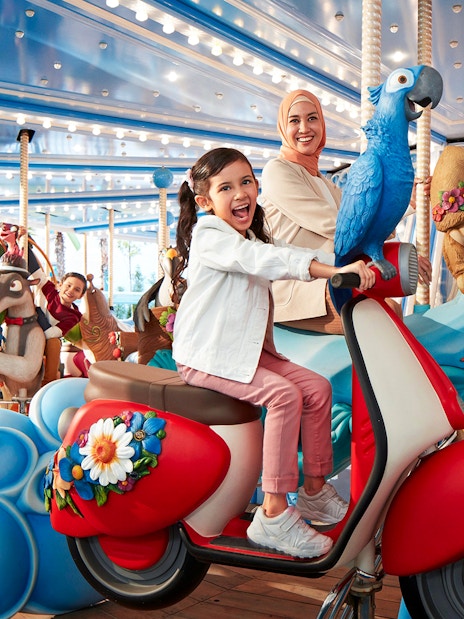Visitors enjoying a colorful carousel ride at Genting SkyWorld Outdoor Theme Park.