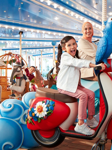 Visitors enjoying a colorful carousel ride at Genting SkyWorld Outdoor Theme Park.