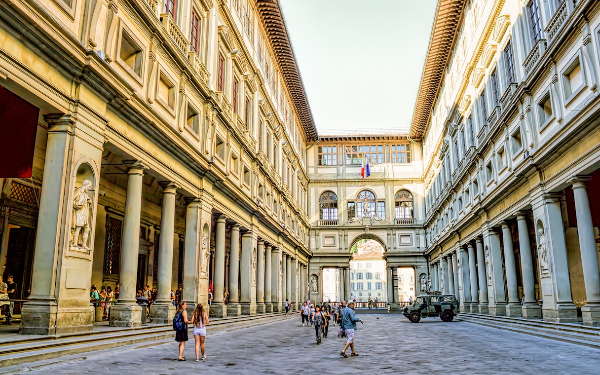 Visitors walking through the courtyard of the Uffizi Gallery in Florence.