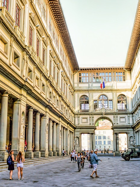 Visitors walking through the courtyard of the Uffizi Gallery in Florence.