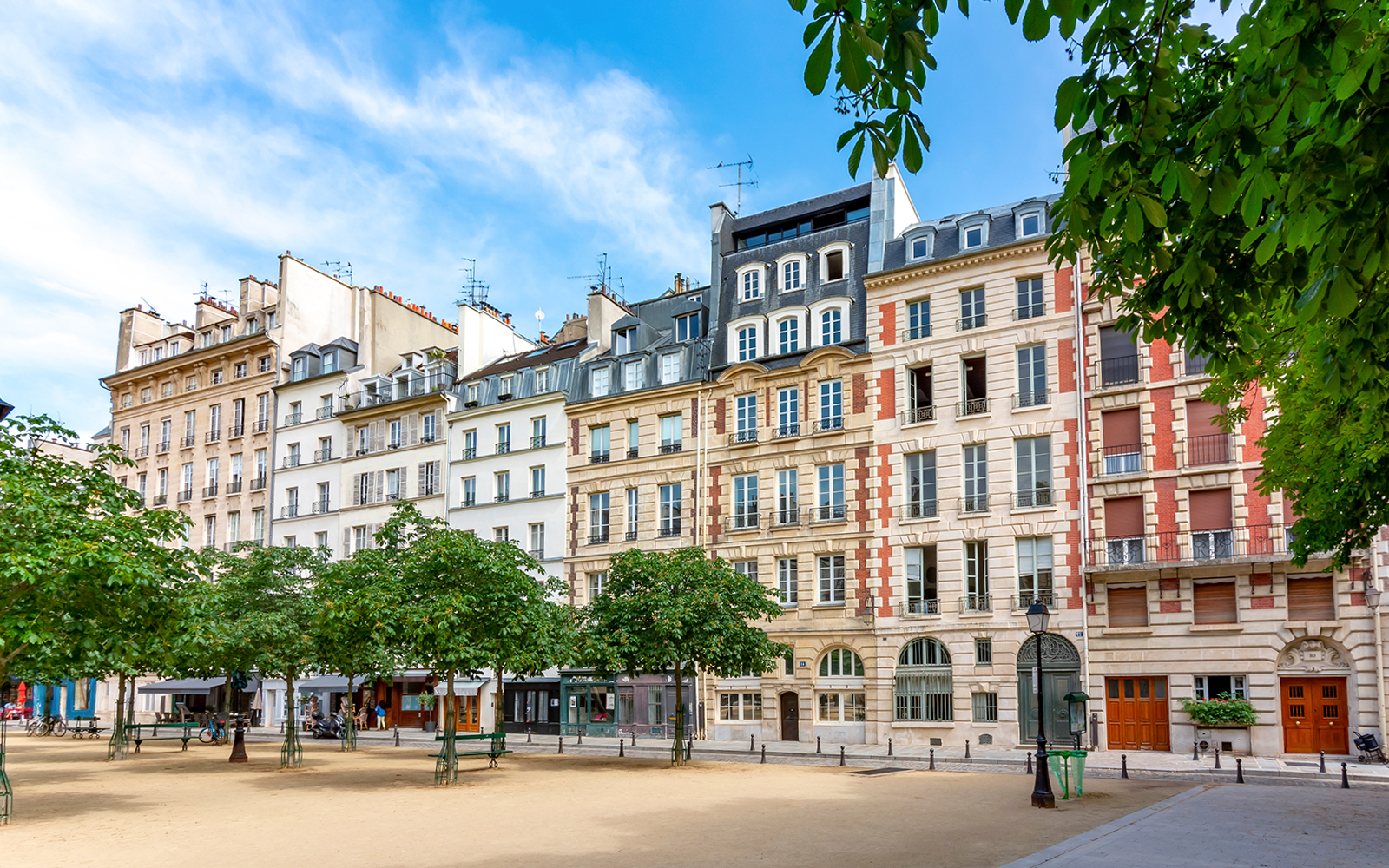 Historic buildings on Notre Dame Island, Paris, with trees lining a quiet square.