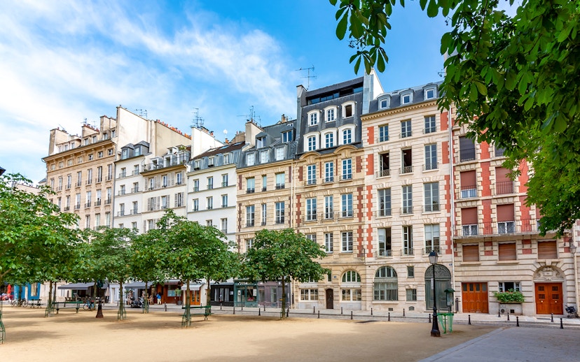 Historic buildings on Notre Dame Island, Paris, with trees lining a quiet square.