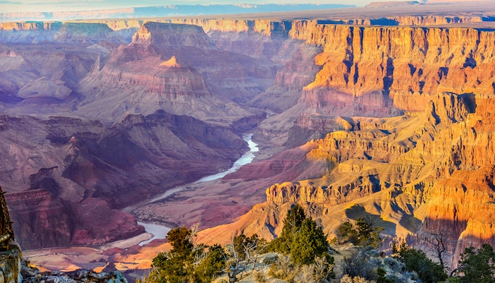 Aerial view of Grand Canyon West during a 20-minute airplane tour showcasing rugged cliffs and winding Colorado River.