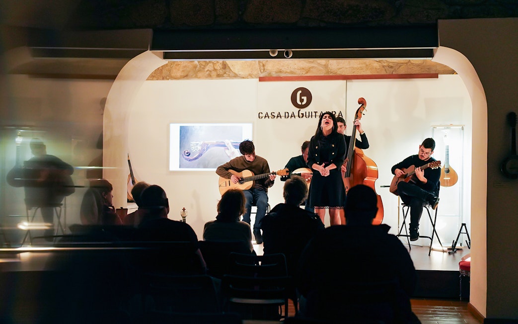 Musicians performing at Casa da Guitarra with Isa de Castro singing.