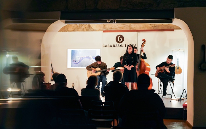 Musicians performing at Casa da Guitarra with Isa de Castro singing.