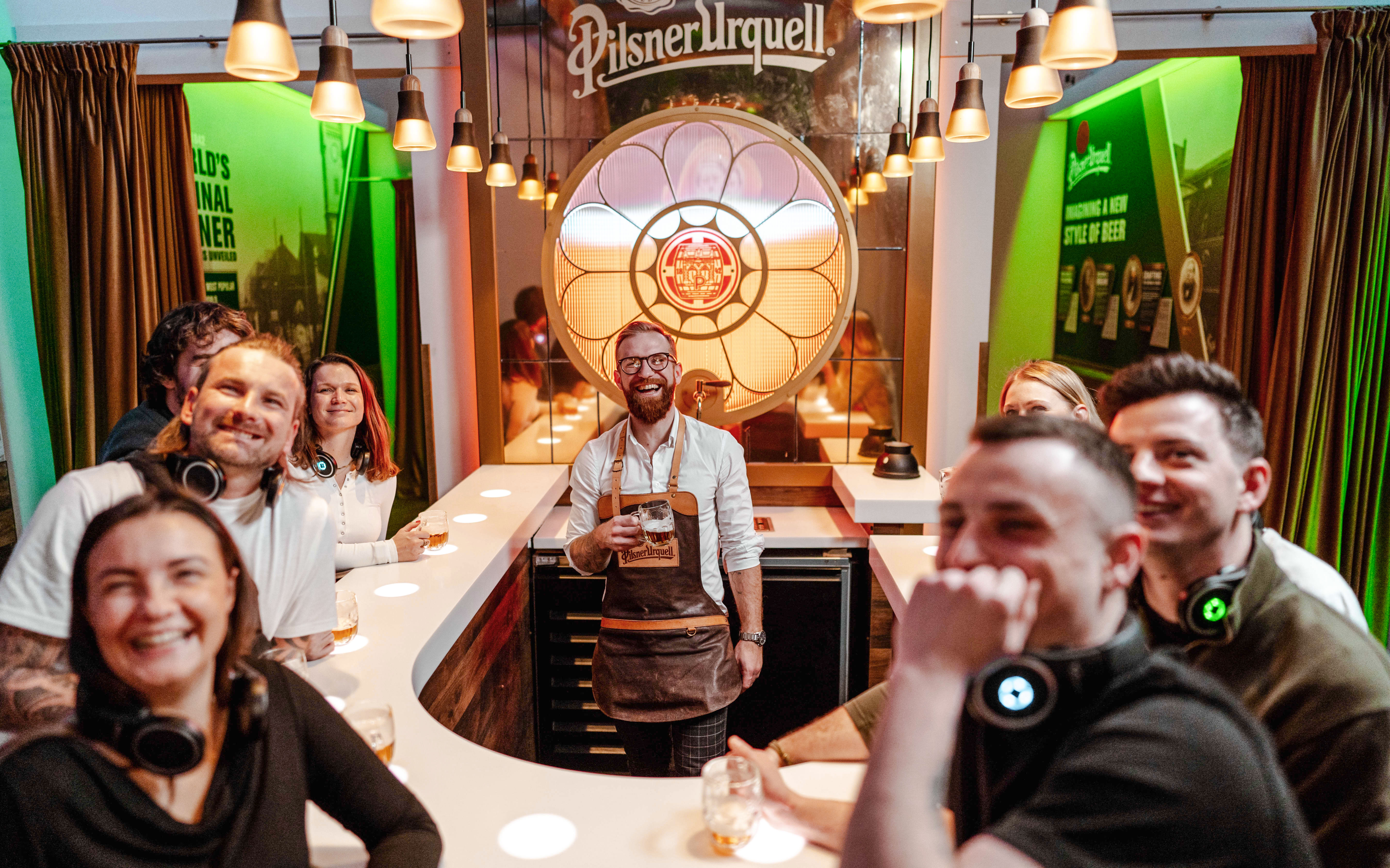 Tourists enjoying beer tasting at Pilsner Urquell Experience bar.