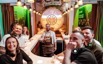 Tourists enjoying beer tasting at Pilsner Urquell Experience bar.