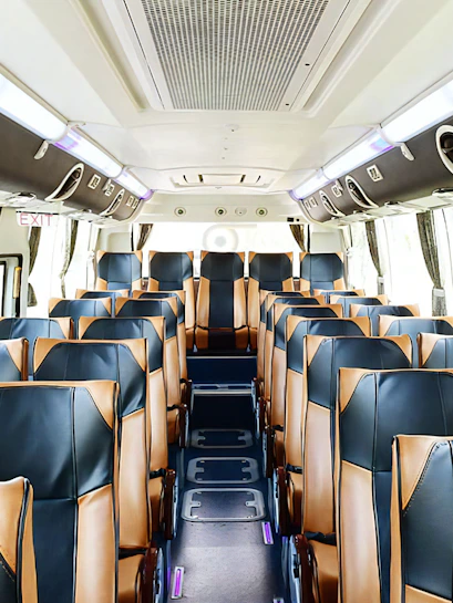 Interior of a tour bus with leather seats, used for transfers from Don Mueang International Airport.