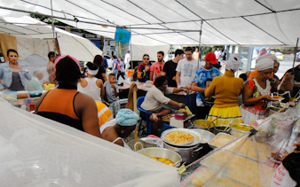Visitors exploring food stalls at Ipanema Street Market with a local guide, Rio de Janeiro.