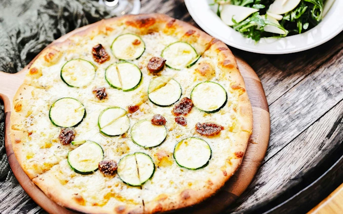 Zucchini and fig pizza served on a wooden board during Yarra Valley Winery Tour.