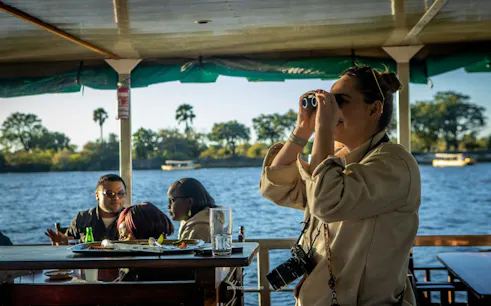 Tourists on a boat enjoying views of the Zambezi River near Victoria Falls.