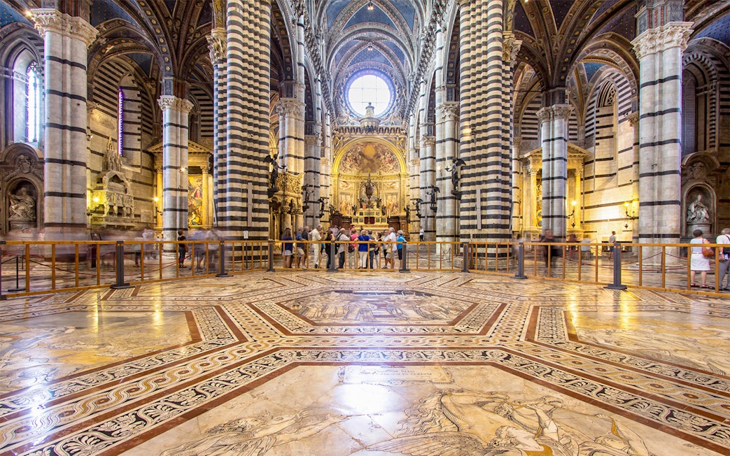 Siena Cathedral interior with ornate marble floor and striped columns, Italy.