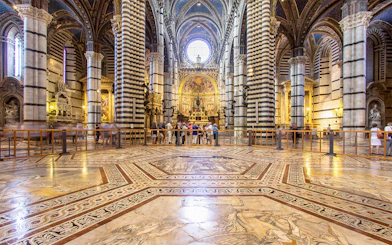 Siena Cathedral interior with ornate marble floor and striped columns, Italy.