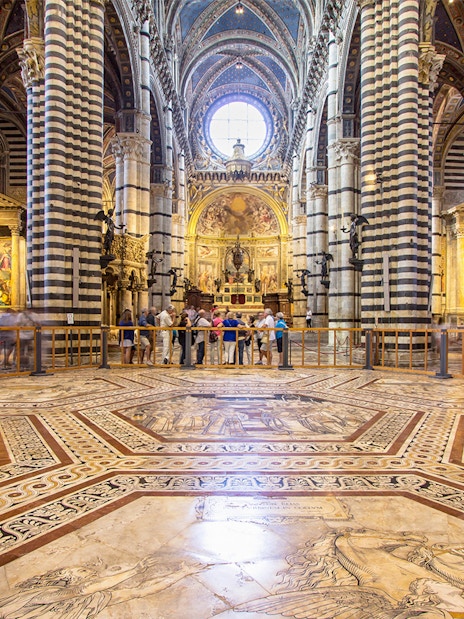 Siena Cathedral interior with ornate marble floor and striped columns, Italy.
