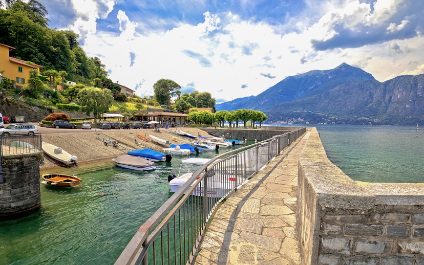 Boats docked at Punta Spartivento viewpoint, Belaggio, with Como Lake and mountains in the background.