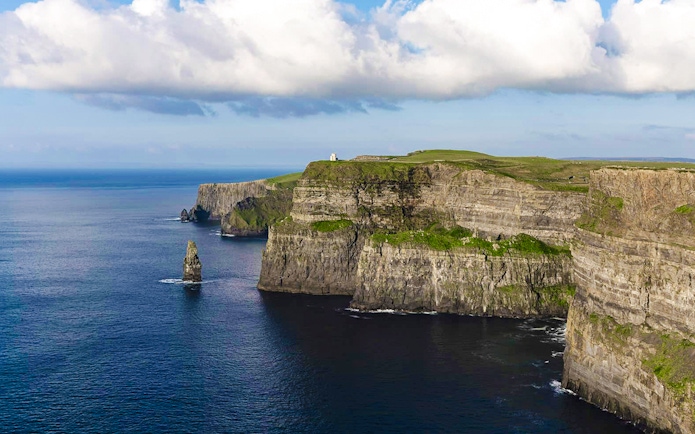 Cliffs of Moher, Ireland, with ocean view and green landscape.