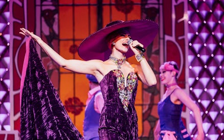 Performer singing at Cabaret La Nouvelle Eve in Paris.