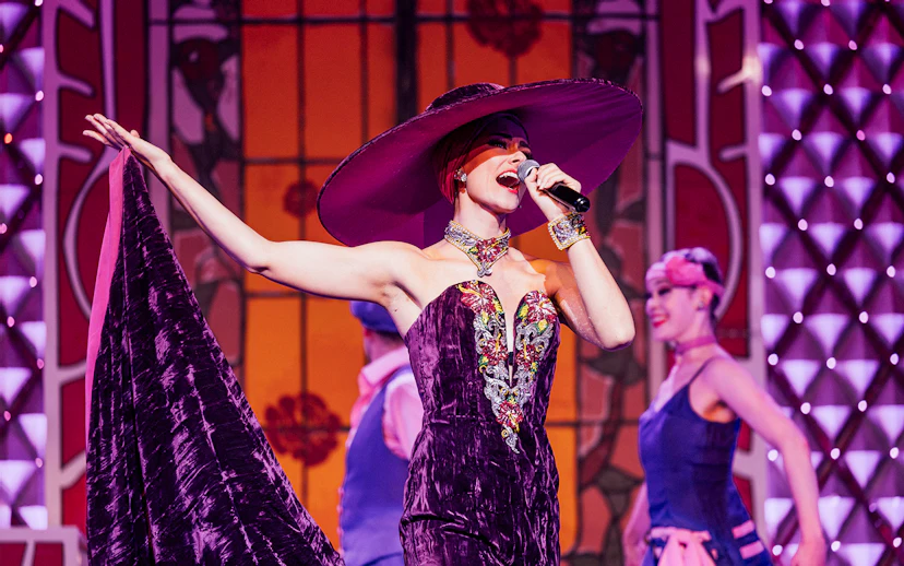 Performer singing at Cabaret La Nouvelle Eve in Paris.