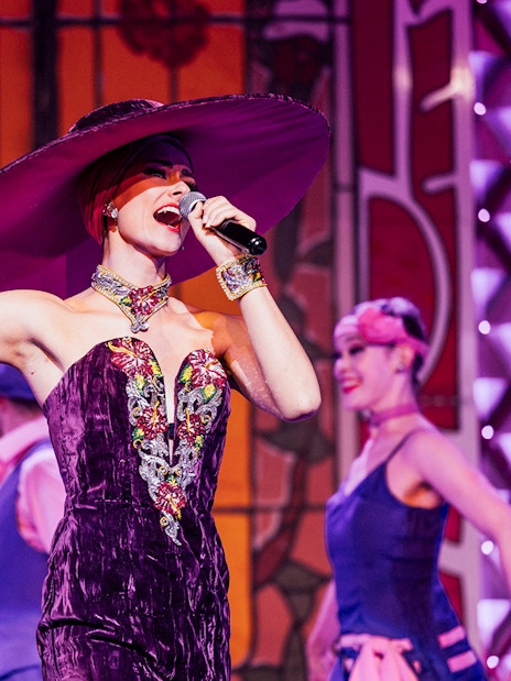 Performer singing at Cabaret La Nouvelle Eve in Paris.