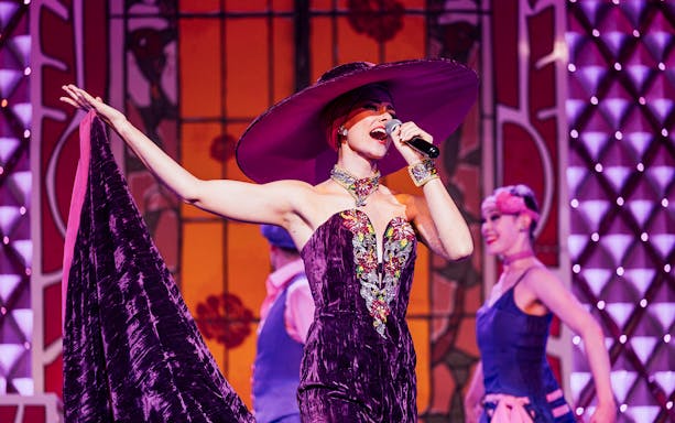 Performer singing at Cabaret La Nouvelle Eve in Paris.
