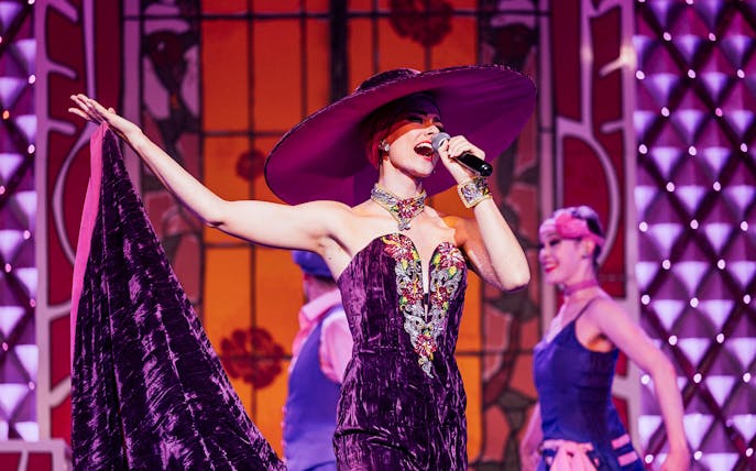 Performer singing at Cabaret La Nouvelle Eve in Paris.