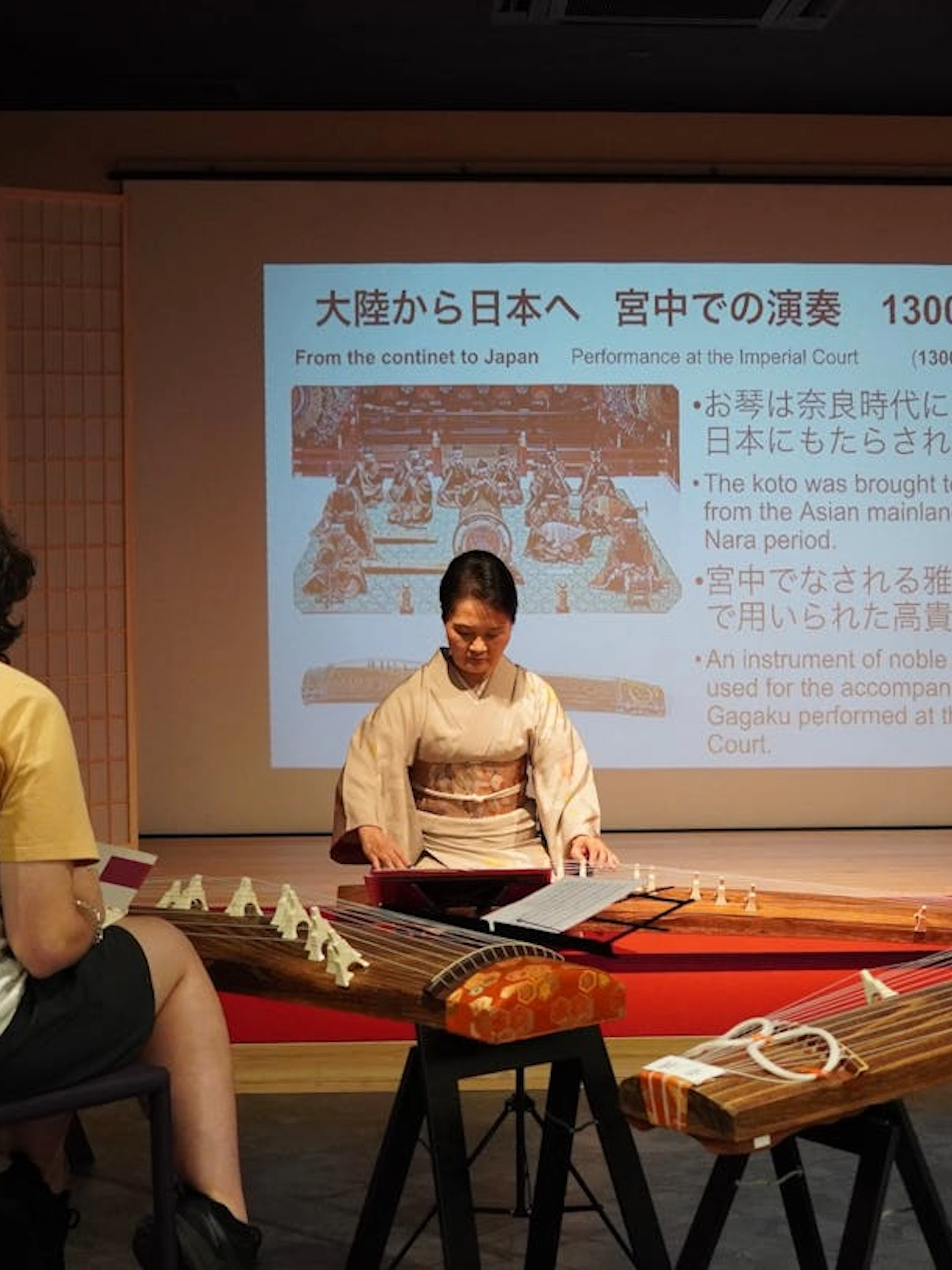 Koto master teaching traditional Japanese instrument lesson in Kyoto classroom.