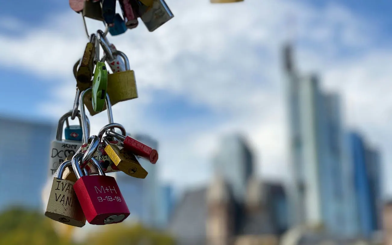 Love locks hanging with Frankfurt skyline in the background.