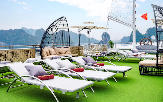 Sun loungers on the deck of Hercules premium cruise with scenic views of limestone karsts.
