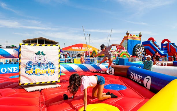 Children playing on inflatable obstacle course at Emirates Dubai 7s event.
